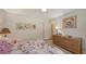 Bright bedroom showcasing a dresser and colorful artwork, illuminated by natural light at 7604 Weeping Willow Cir, Sarasota, FL 34241