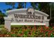 A view of the Woodlands II at Bent Tree community entrance sign surrounded by flower beds at 7604 Weeping Willow Cir, Sarasota, FL 34241