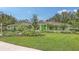 Beautifully landscaped front yard with mature trees and a well-maintained lawn at 7604 Weeping Willow Cir, Sarasota, FL 34241