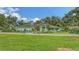 Landscaped home featuring a vibrant green lawn and mature trees under a blue sky at 7604 Weeping Willow Cir, Sarasota, FL 34241