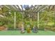 A beautiful garden featuring statues, garden sign and a pergola with climbing plants and lush foliage creating a tranquil oasis at 7604 Weeping Willow Cir, Sarasota, FL 34241