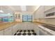 Well-lit kitchen featuring white cabinets, granite countertops, and black and white checkered floors at 7604 Weeping Willow Cir, Sarasota, FL 34241