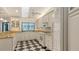 Bright kitchen with white cabinets, granite countertops, and a black and white checkered floor at 7604 Weeping Willow Cir, Sarasota, FL 34241