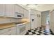 Bright kitchen featuring white cabinets, granite countertops, and black and white checkered floors at 7604 Weeping Willow Cir, Sarasota, FL 34241