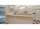 Bright kitchen featuring granite countertops, white cabinets, and an adjacent view of the outdoor pool area at 7604 Weeping Willow Cir, Sarasota, FL 34241