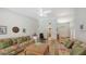 Spacious living room featuring hardwood floors, tropical furniture, and a view of the front entrance at 7604 Weeping Willow Cir, Sarasota, FL 34241