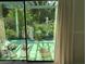 View of the landscaped patio, accessed through sliding glass doors, offering a serene outdoor space at 7604 Weeping Willow Cir, Sarasota, FL 34241