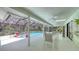 Screened-in pool area featuring multiple ceiling fans for air circulation and an outdoor dining area at 7604 Weeping Willow Cir, Sarasota, FL 34241