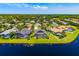 Breathtaking aerial view of a community showcasing lush landscaping, pools, and beautiful homes nestled around a serene lake at 7727 Heyward Cir, University Park, FL 34201