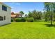 Lush backyard showcasing a sprawling lawn and established landscaping, ideal for outdoor activities at 7727 Heyward Cir, University Park, FL 34201