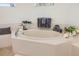 Bright bathroom featuring a soaking tub, decorative accents, and neutral tile at 7727 Heyward Cir, University Park, FL 34201