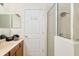 Bathroom with vanity, mirror, towels, and a glass-enclosed shower at 7727 Heyward Cir, University Park, FL 34201