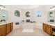 Bathroom featuring a large tub, arched windows, and double vanities at 7727 Heyward Cir, University Park, FL 34201