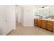 Bathroom featuring tile floors, wood vanity, and adjacent hallway at 7727 Heyward Cir, University Park, FL 34201