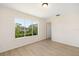 Bedroom with a large window showcasing an attractive view and wood-look flooring at 7727 Heyward Cir, University Park, FL 34201