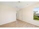 Bright bedroom with wood-look flooring and a window with backyard views at 7727 Heyward Cir, University Park, FL 34201