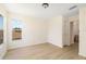 Bright bedroom featuring wood floors, a window, and a door to an ensuite bathroom at 7727 Heyward Cir, University Park, FL 34201