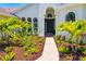 Inviting home entrance with a beautifully landscaped front yard and arched windows at 7727 Heyward Cir, University Park, FL 34201