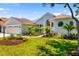 Charming home exterior featuring a well-manicured lawn, landscaping and attached garage at 7727 Heyward Cir, University Park, FL 34201