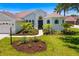 Beautiful front yard with walkway leading to home, lush garden beds, and palm trees at 7727 Heyward Cir, University Park, FL 34201