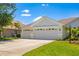 Spacious three-car garage with a well-manicured lawn and landscaping at 7727 Heyward Cir, University Park, FL 34201