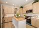 Bright kitchen with stainless steel appliances, wood island top, and neutral cabinets at 7727 Heyward Cir, University Park, FL 34201
