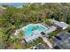 Aerial view of community pool with lounge areas, palm trees, and clubhouse at 7727 Heyward Cir, University Park, FL 34201