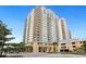 View of the building's exterior featuring its grand architecture, lush landscaping, and convenient guest parking area at 800 N Tamiami Trl # 405, Sarasota, FL 34236