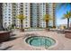 Inviting outdoor hot tub with views of a modern condo building and lush landscaping at 800 N Tamiami Trl # 405, Sarasota, FL 34236