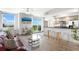 Spacious open-concept living room with a kitchen bar, large windows offering stunning views, and stylish furnishings at 800 N Tamiami Trl # 405, Sarasota, FL 34236