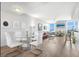 Well-lit living and dining area with wood floors, modern furnishings, and stunning water view from the large windows at 800 N Tamiami Trl # 405, Sarasota, FL 34236