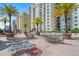Luxurious pool deck featuring comfortable lounge chairs, dining tables, and lush palm trees at 800 N Tamiami Trl # 405, Sarasota, FL 34236