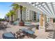 Tranquil pool area with comfortable seating, lush palm trees, and scenic views of the building at 800 N Tamiami Trl # 405, Sarasota, FL 34236