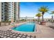Stunning pool area with clear blue water, surrounded by a modern building and swaying palm trees at 800 N Tamiami Trl # 405, Sarasota, FL 34236
