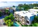 Aerial view of a modern white building with balconies, a refreshing pool, and lush tropical surroundings at 804 N Shore Dr, Anna Maria, FL 34216