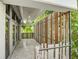 Wide balcony with light tile flooring, tall doors, and wood slat railings with tropical views at 804 N Shore Dr, Anna Maria, FL 34216