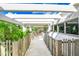 A bright balcony shows wooden railings and chairs in a white exterior at 804 N Shore Dr, Anna Maria, FL 34216
