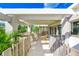 A covered balcony with stylish outdoor seating, providing a relaxing and inviting outdoor space at 804 N Shore Dr, Anna Maria, FL 34216