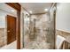 Bathroom with glass-enclosed shower with neutral tile surround and bench seat at 804 N Shore Dr, Anna Maria, FL 34216