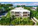 Beautiful multi-story building with balconies surrounded by lush, tropical landscaping, and ocean views at 804 N Shore Dr, Anna Maria, FL 34216