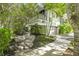 Beautiful home featuring a stone walkway and lush trees and manicured lawns at 804 N Shore Dr, Anna Maria, FL 34216