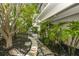 Exterior view with a stone walkway leading to a gate, and lush landscaping at 804 N Shore Dr, Anna Maria, FL 34216