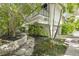 Stunning home features a manicured lawn, stone walkway, and a second-story balcony at 804 N Shore Dr, Anna Maria, FL 34216