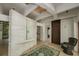 Bright foyer with brick accent wall, tile floor, and woven chair at 804 N Shore Dr, Anna Maria, FL 34216