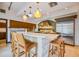 Bright kitchen with stainless steel appliances, modern cabinets, breakfast bar, and unique lighting at 804 N Shore Dr, Anna Maria, FL 34216