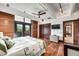 Bright main bedroom with hardwood floors, area rug, television, closet, and balcony at 804 N Shore Dr, Anna Maria, FL 34216