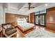 Spacious main bedroom with hardwood floors, area rug, wood wall paneling, and a balcony at 804 N Shore Dr, Anna Maria, FL 34216