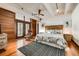 Bright main bedroom with wood floors, ceiling fan, wood-slat wall and door, and black/white rug at 804 N Shore Dr, Anna Maria, FL 34216