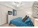 Bedroom with a blue patterned bedspread, ceiling fan and a television on a dresser at 850 Tidewater Shores Loop # 102, Bradenton, FL 34208