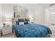 Comfortable bedroom with a decorative mirror, a bed with stylish bedding and a view to the bath at 850 Tidewater Shores Loop # 102, Bradenton, FL 34208